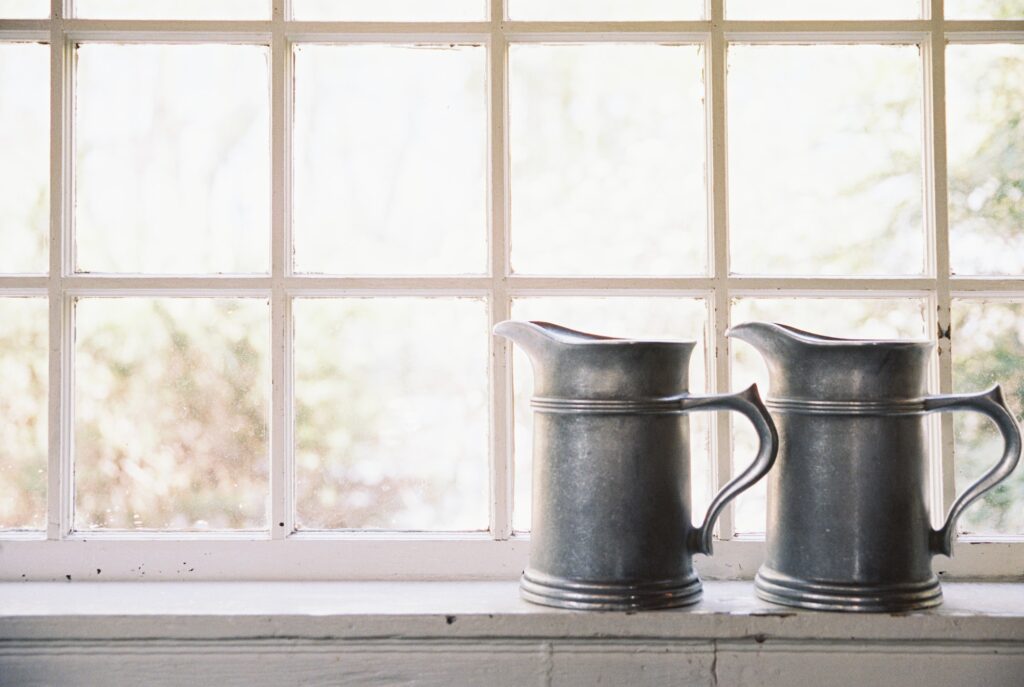 Interior view of a historic house, window sill and pewter drinking jugs