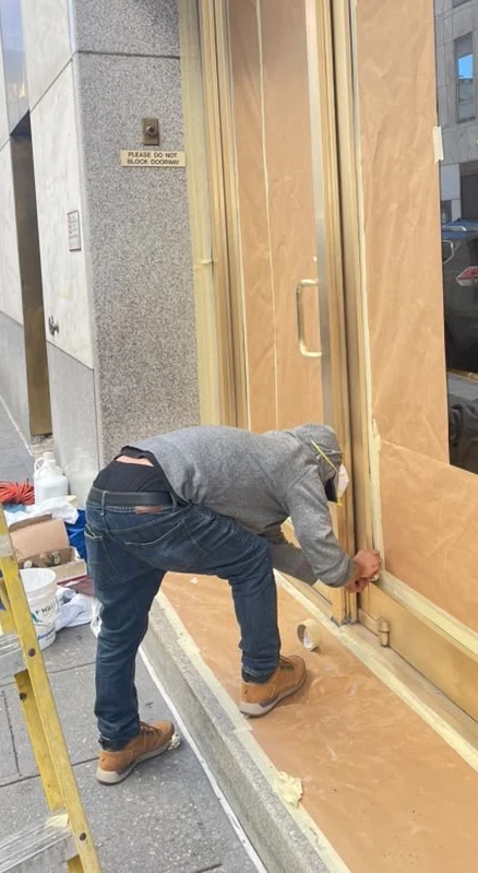 Metal Man Restoration crew member masking a brass entranceway on site in Newark, New Jersey