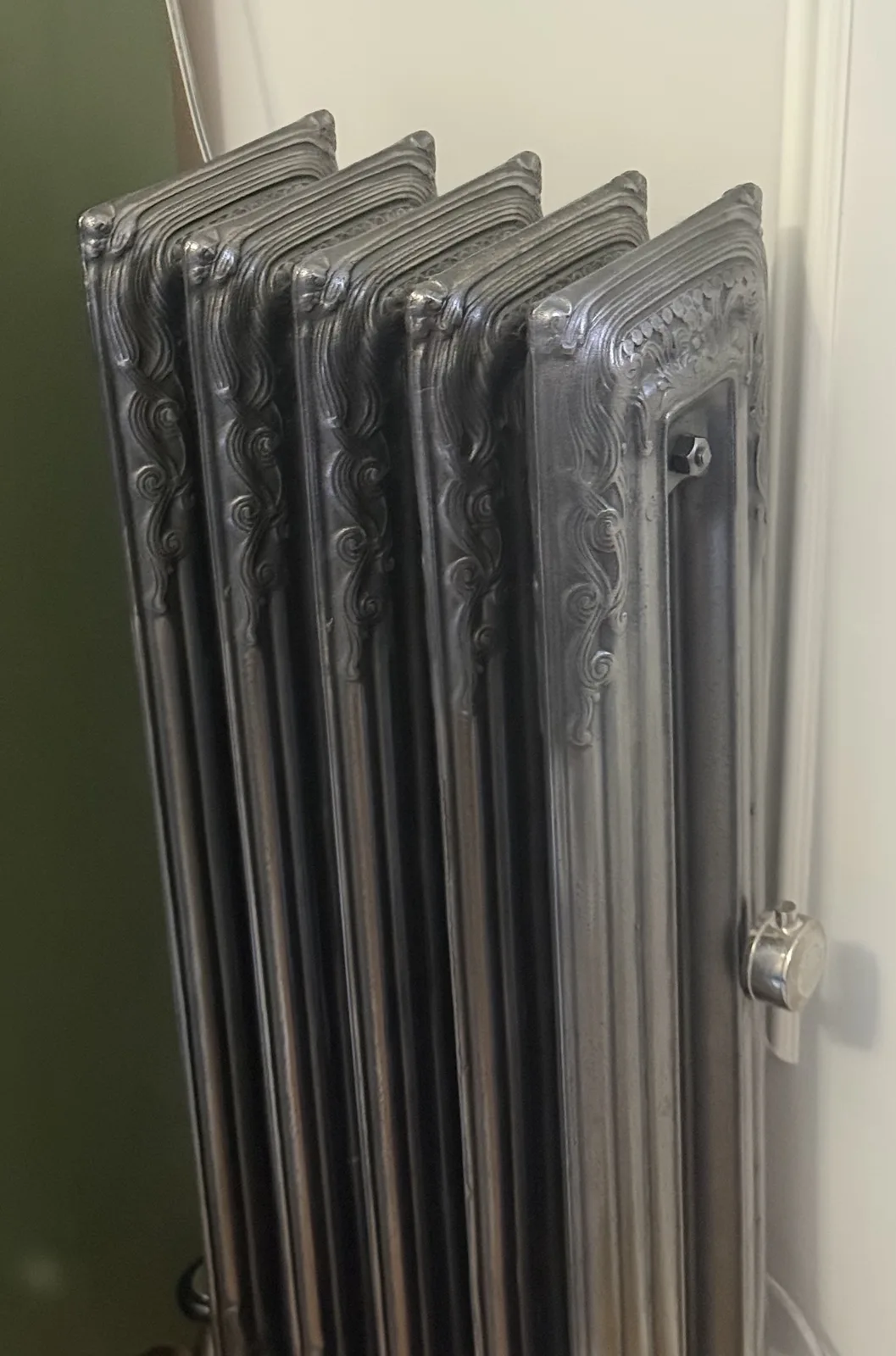 Polished and oxidized Rococo II cast iron radiator showing the ornate casting after restoration